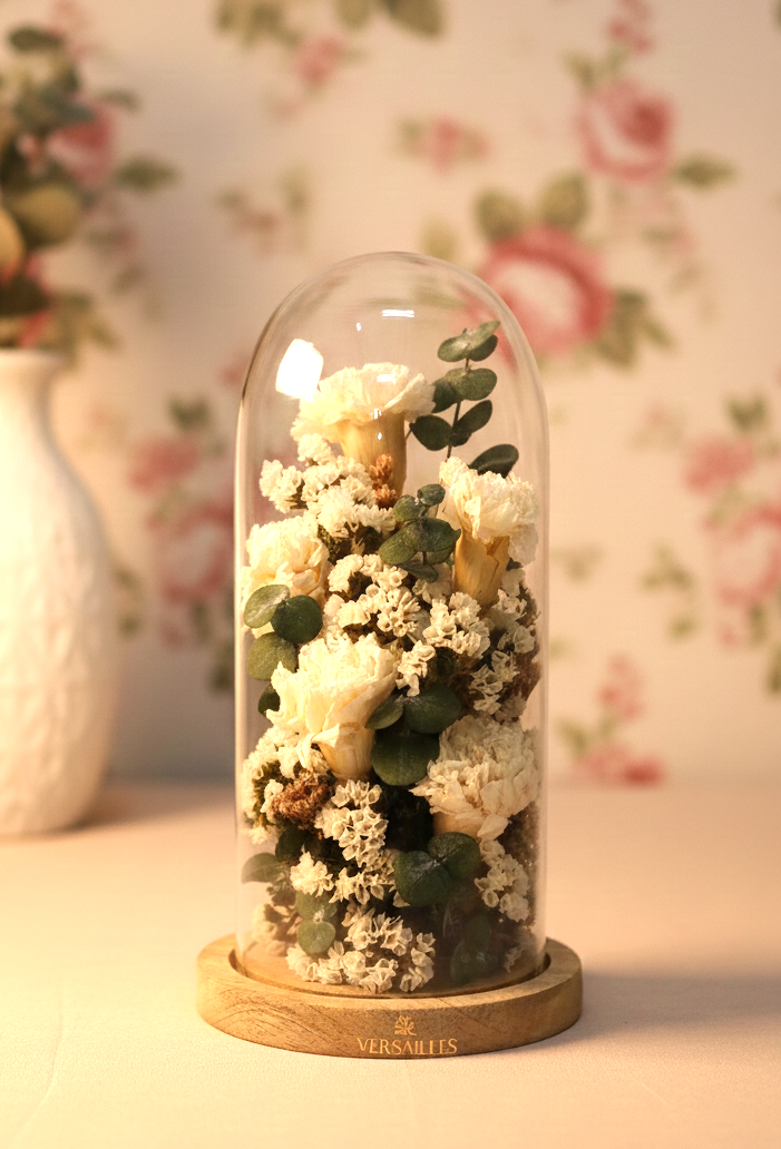 Decorative glass dome with preserved flowers on a floral wallpaper background
