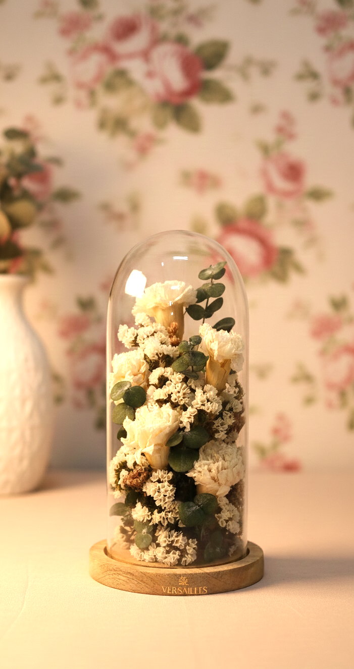 Decorative glass dome with preserved flowers on a floral wallpaper background